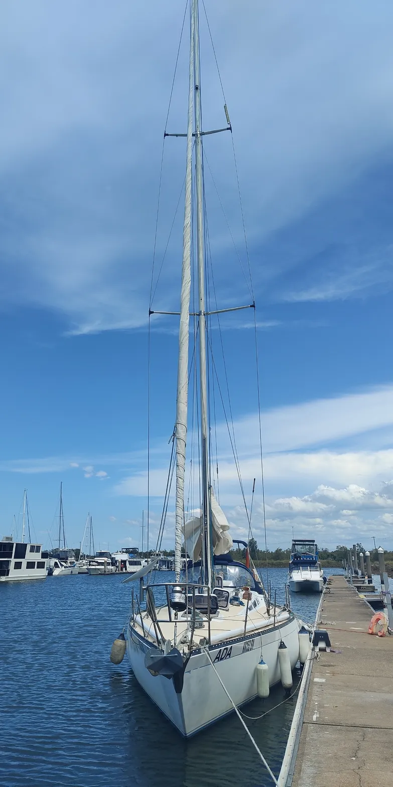 The yacht Ada moored beside a dock under a blue sky.