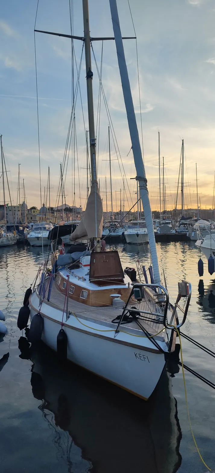 The yacht Kefi moored in a marina at sunset.